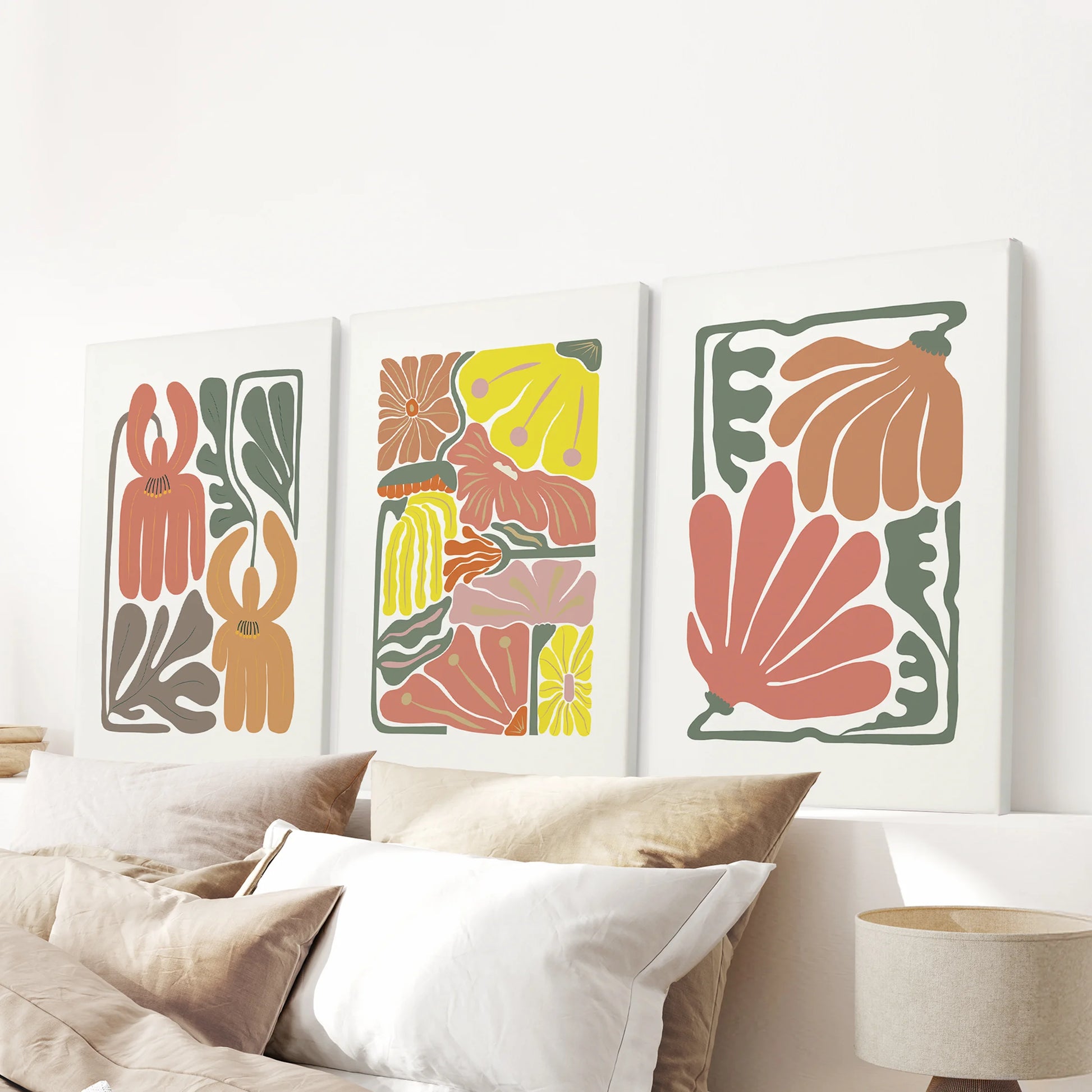 Boho flower market posters, a set of three canvas prints, are shown above the bedroom bed, their terracotta botanicals adding warmth and texture without frames.