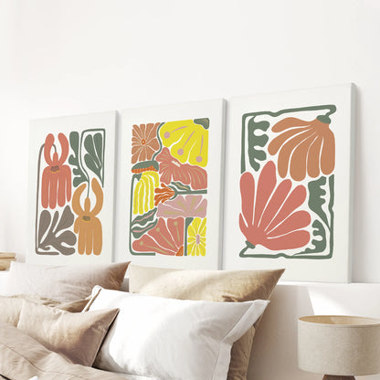 Boho flower market posters, a set of three canvas prints, are shown above the bedroom bed, their terracotta botanicals adding warmth and texture without frames.