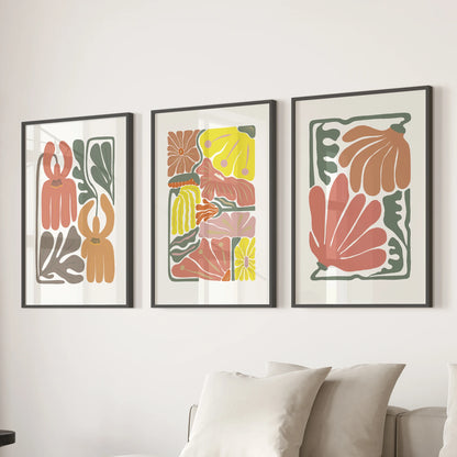 Three terracotta floral prints in crisp black frames line the lounge wall above the sectional, giving the space a clean, modern botanical mood.