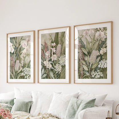 The three prints above a sofa show pale orchids and textured flower heads against mottled beige and green, enclosed in oak frames with white mats.