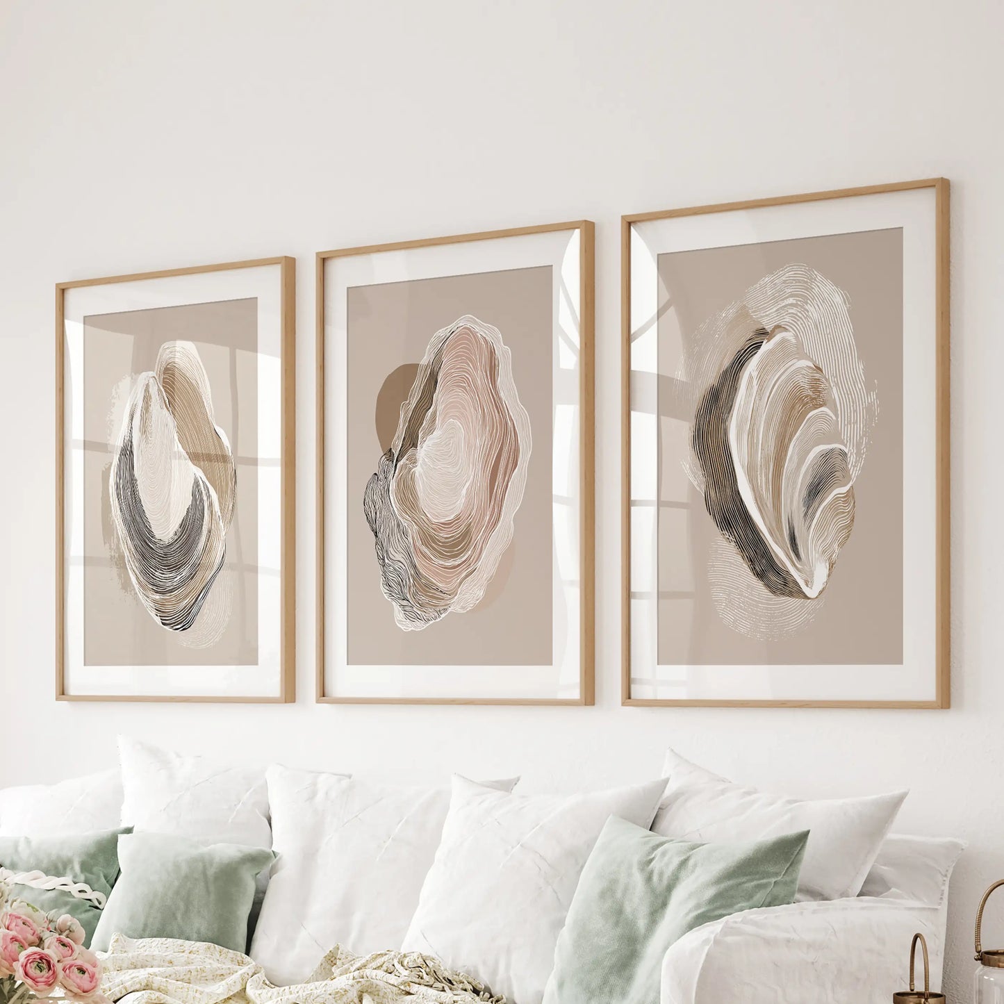 Oyster shell sketches, a set of three pictures matted in wood frames, line the living room wall behind the sofa for a crisp coastal focal point.