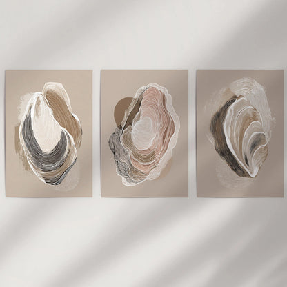 Three beige oyster art prints appear rolled and unframed, ready for a simple wall that favors understated coastal ease.