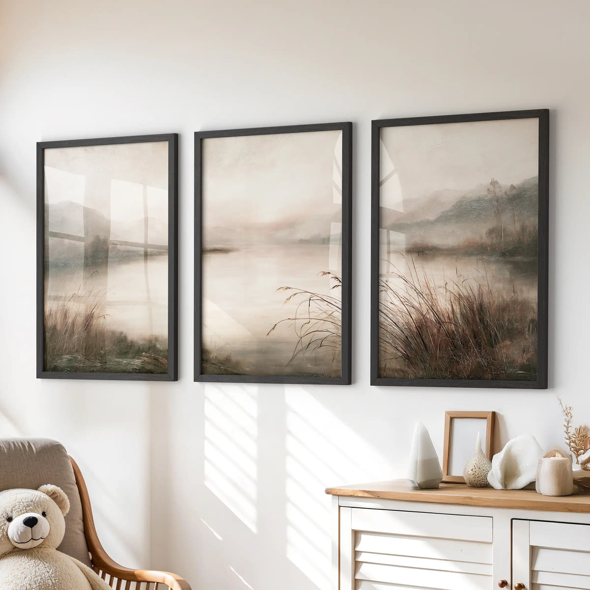 Three-piece pastoral landscape print set in black frames, displayed above a chest of drawers in a children's room.