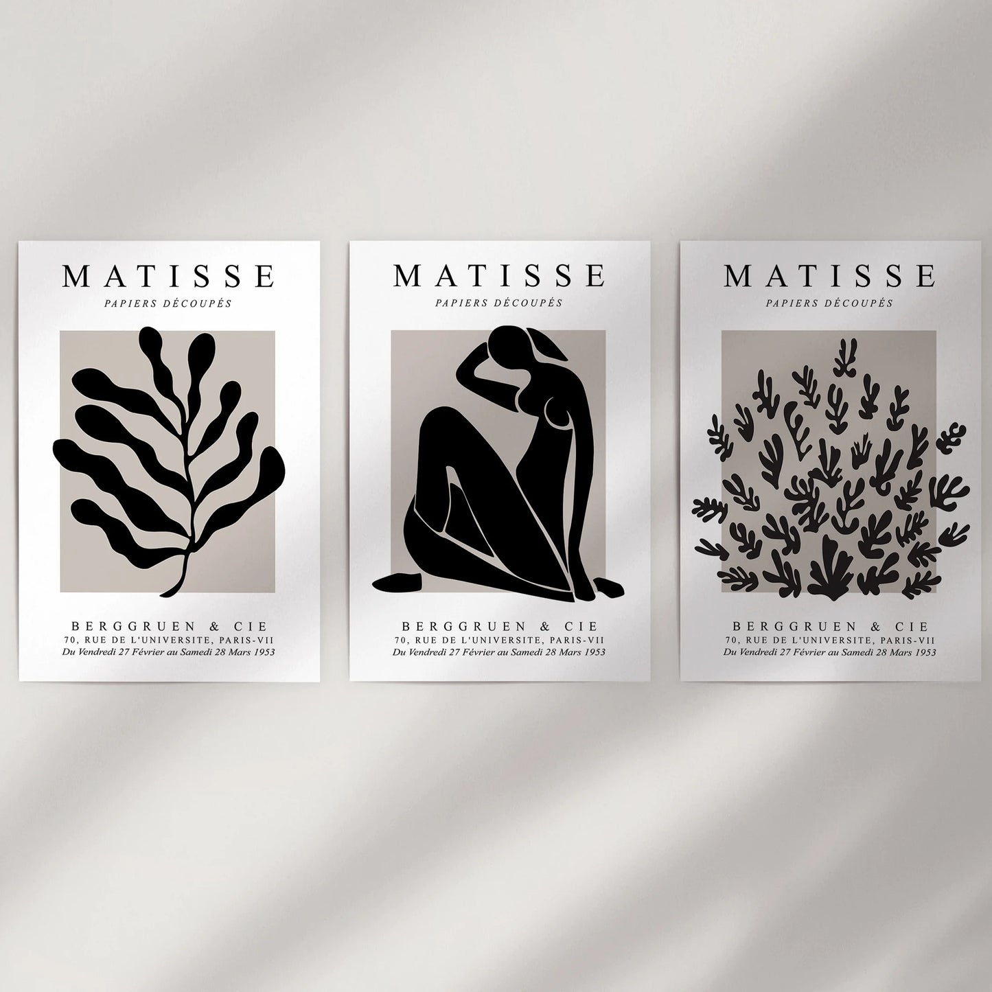 Mid-century modern art, a three-piece poster set shown unframed, adds graphic wall decor to a plain wall.