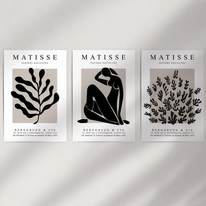 Mid-century modern art, a three-piece poster set shown unframed, adds graphic wall decor to a plain wall.