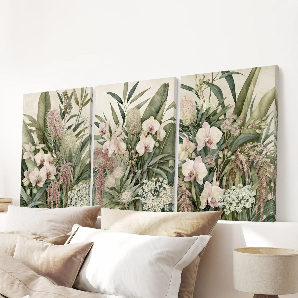 The three canvases above a bed show pale orchids, rounded flower heads and small white blooms among broad green leaves and trailing pink stems.