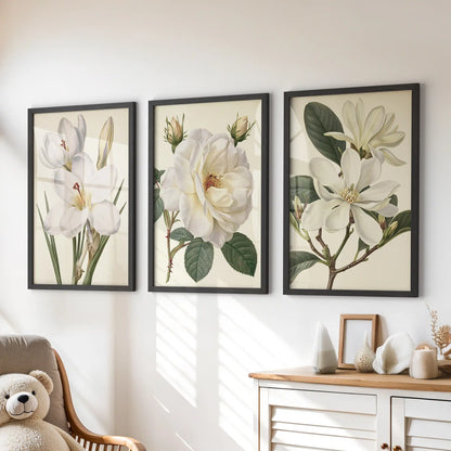 Above a dresser in a kids' room, black frames surround three prints of white petals and green leaves on cream backgrounds.