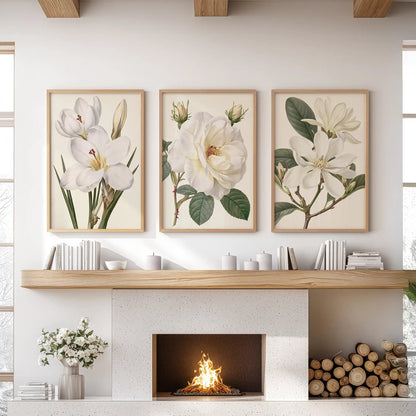 Above a fireplace, oak frames surround three prints of white petals and green leaves on cream backgrounds.