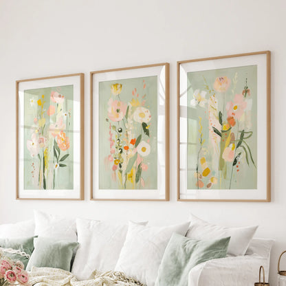 A matted trio of pink and green floral art prints in slim wood frames rests above the sitting room sectional.