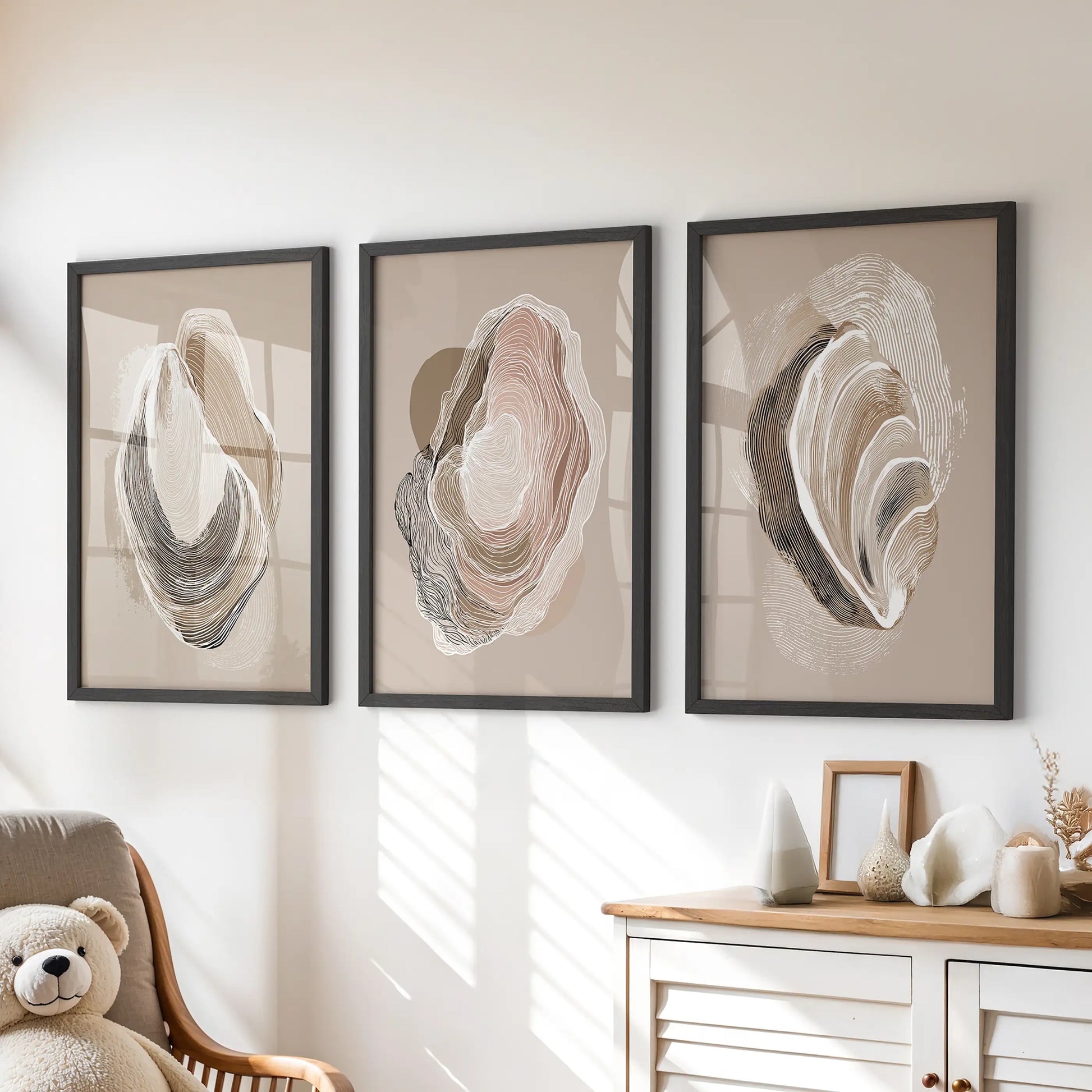 Minimalist shell illustrations, a set of three posters in black frames, hang over the playroom drawers to lend calm, tactile seaside character.