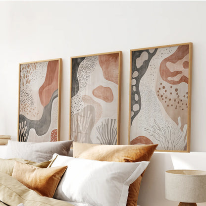 Organic minimalist art, a three-piece wall art set in warm wood frames, centers the bedroom above the headboard with soft, balanced forms.