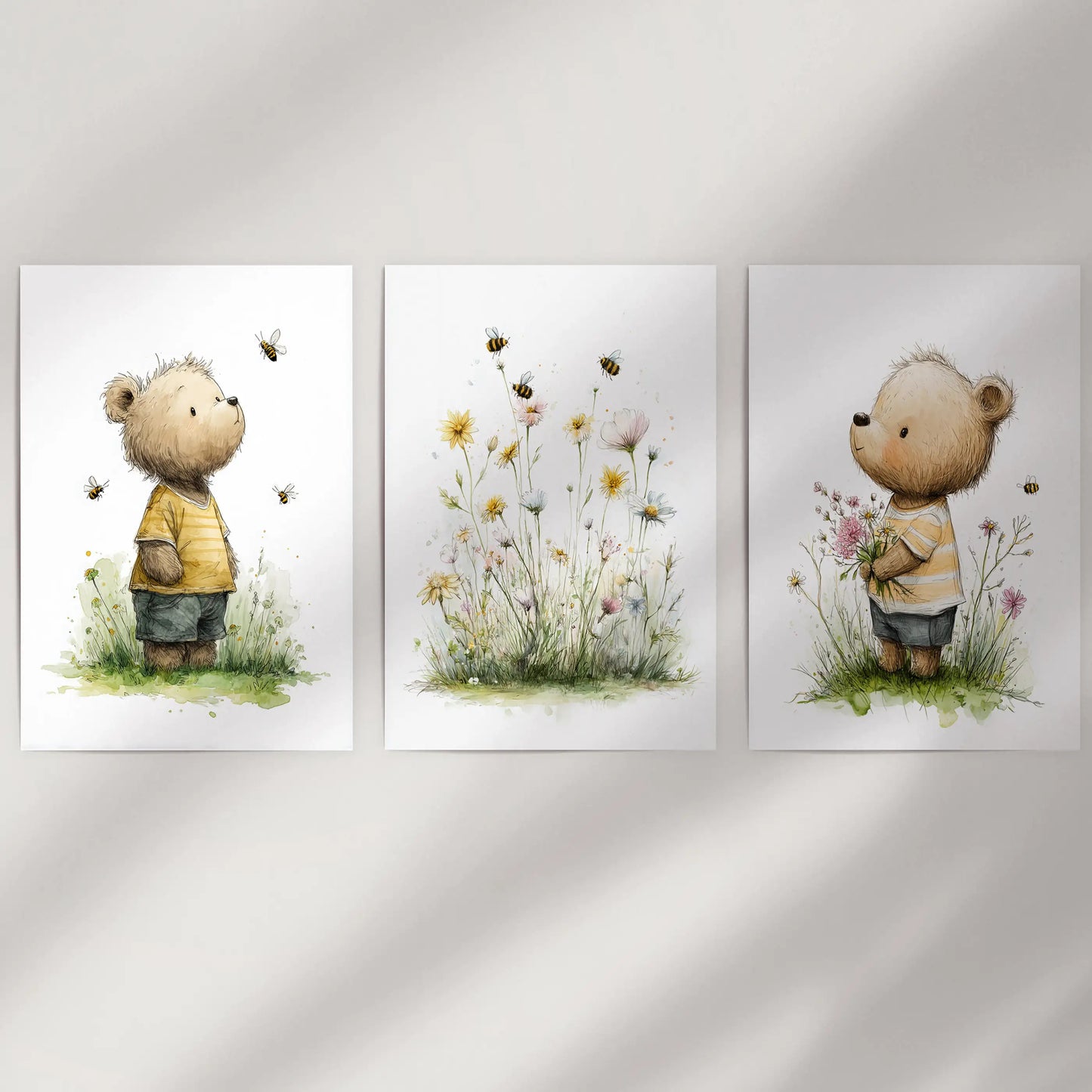 Unframed baby teddy bear prints with floral touches form a clean three-piece wall art display, styled simply against an empty wall.