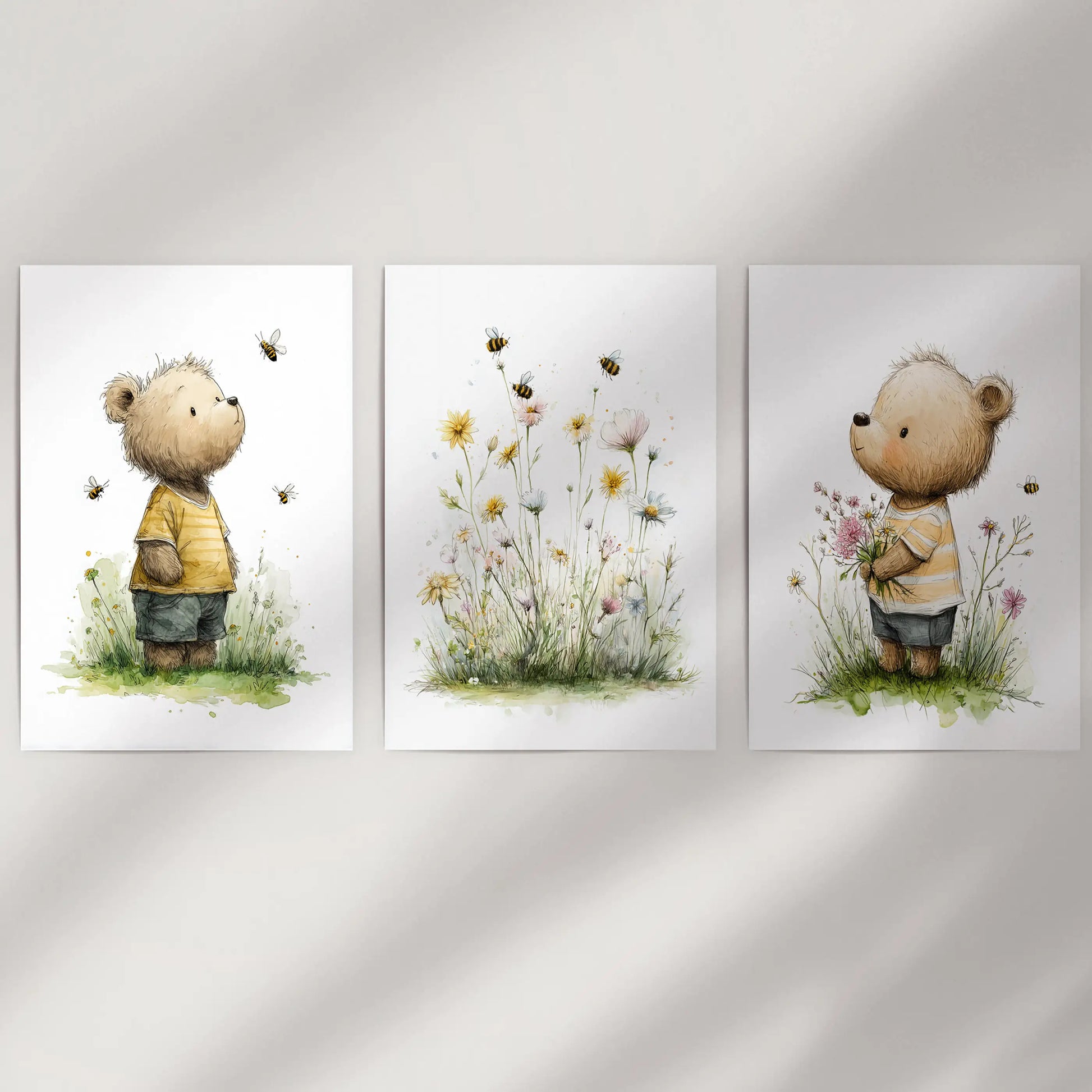 Unframed baby teddy bear prints with floral touches form a clean three-piece wall art display, styled simply against an empty wall.