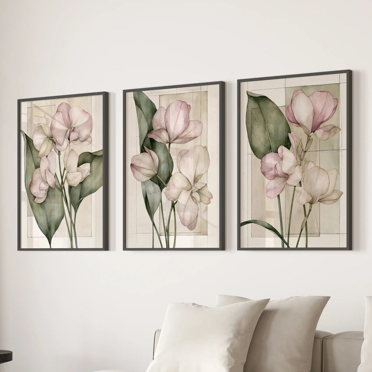 Pale petals and slender green stems overlap faint rectangular outlines in three black-framed floral prints above a sofa.