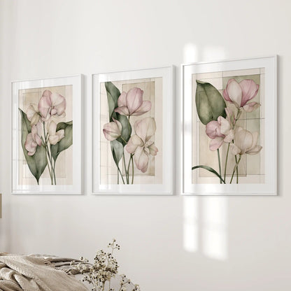 The three white frames beside a bed have mats around pink flowers and dark leaves, with pale rectangular outlines behind the stems.