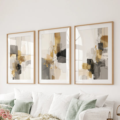 A trio of matted wall prints in natural oak frames shows gold-toned strokes that finish the lounge wall behind the couch with restraint.
