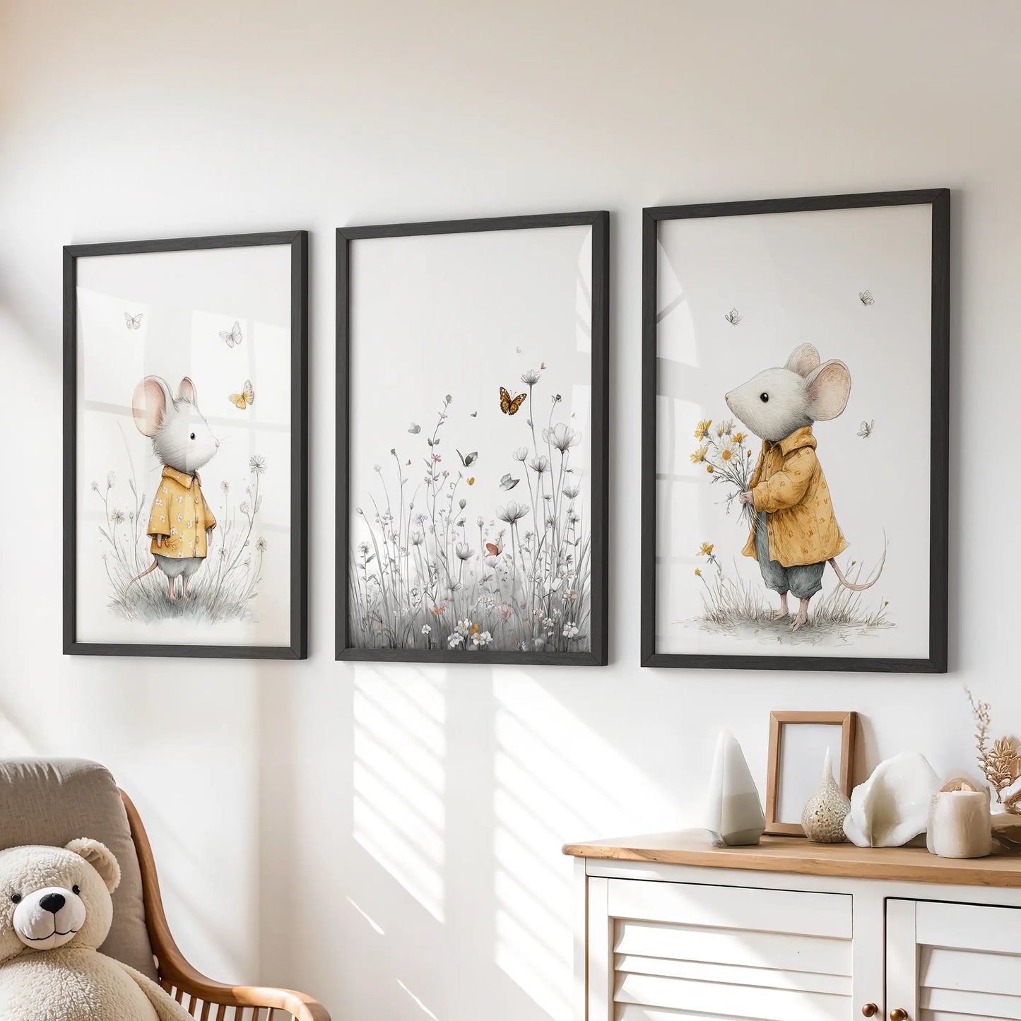 Soft floral mouse prints, a set of three black-framed pieces, hang above the dresser to create soothing, gender-neutral wall art for a child’s room.