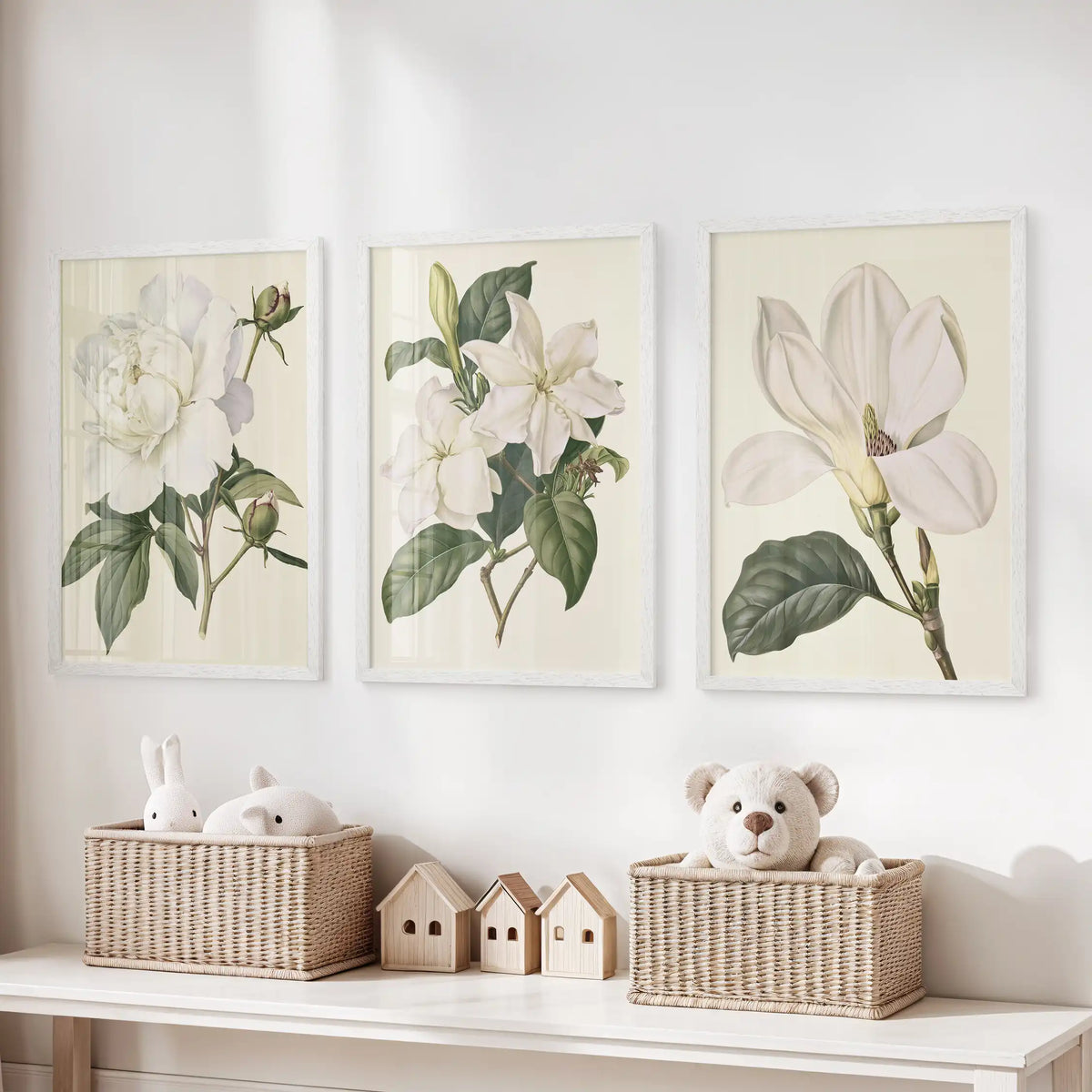 A ruffled bloom, smaller white blossoms and a single open flower fill three white-framed prints above baskets of toys.