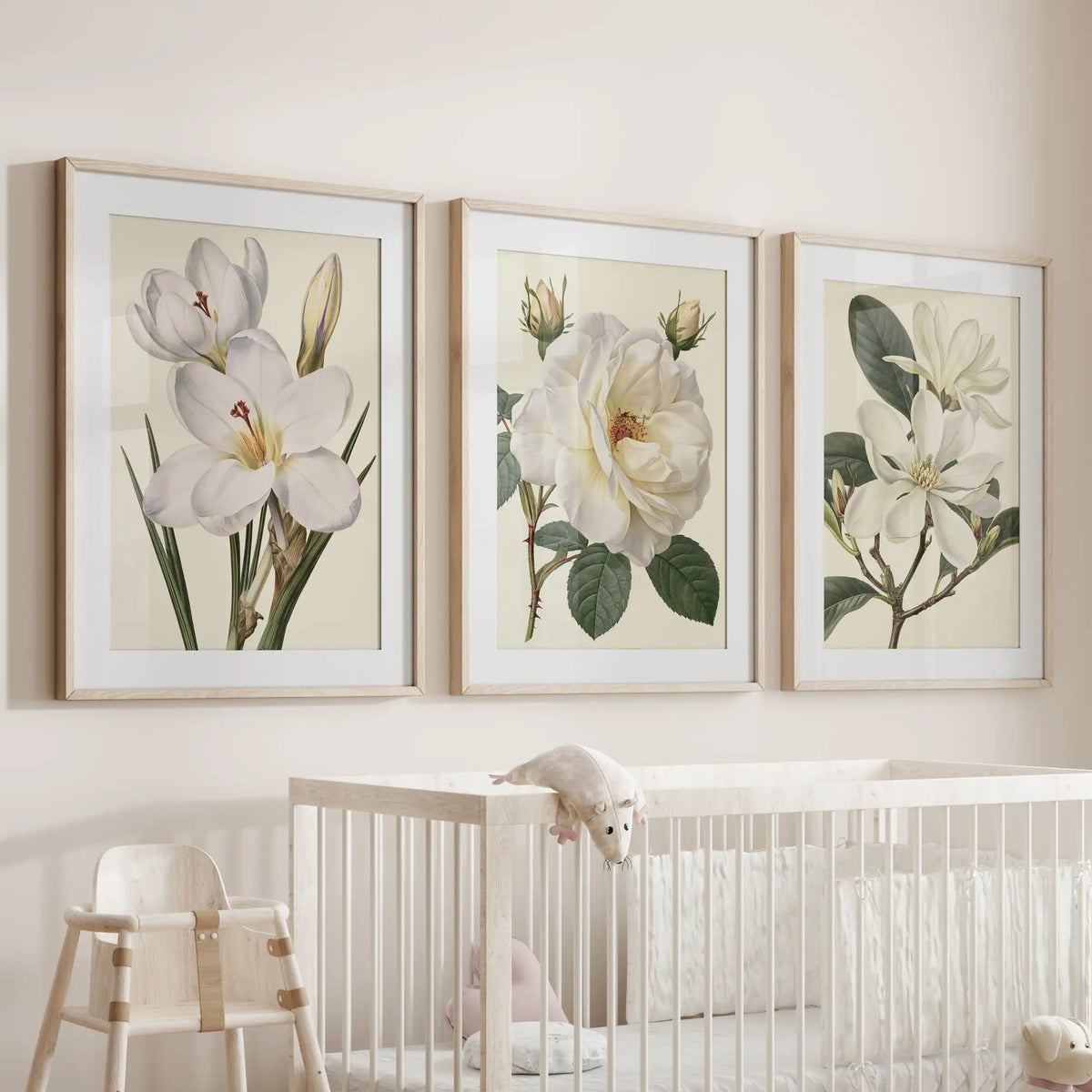 Oak frames with white mats surround three white botanical prints above a crib.
