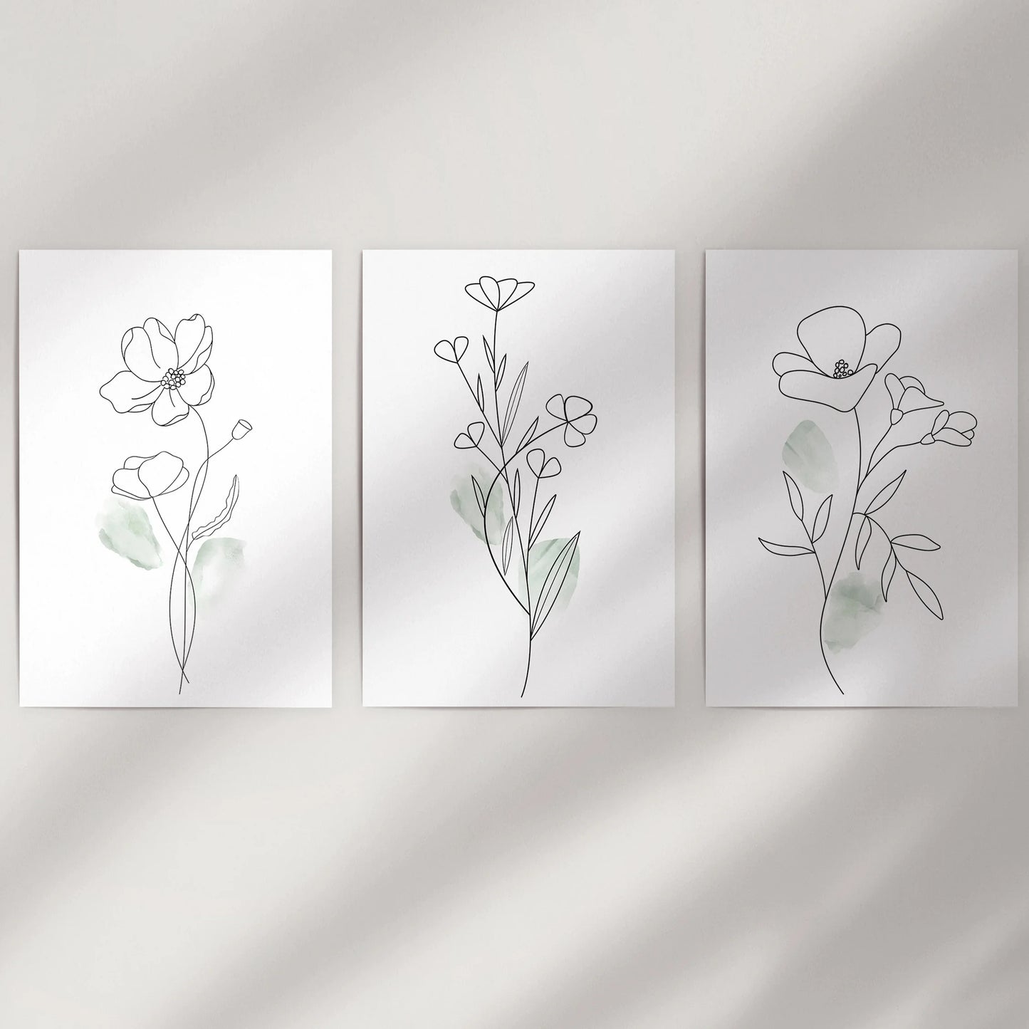 Unframed black line wildflower prints come rolled as a three-piece set, ready to fill an empty wall with clean, organic movement.