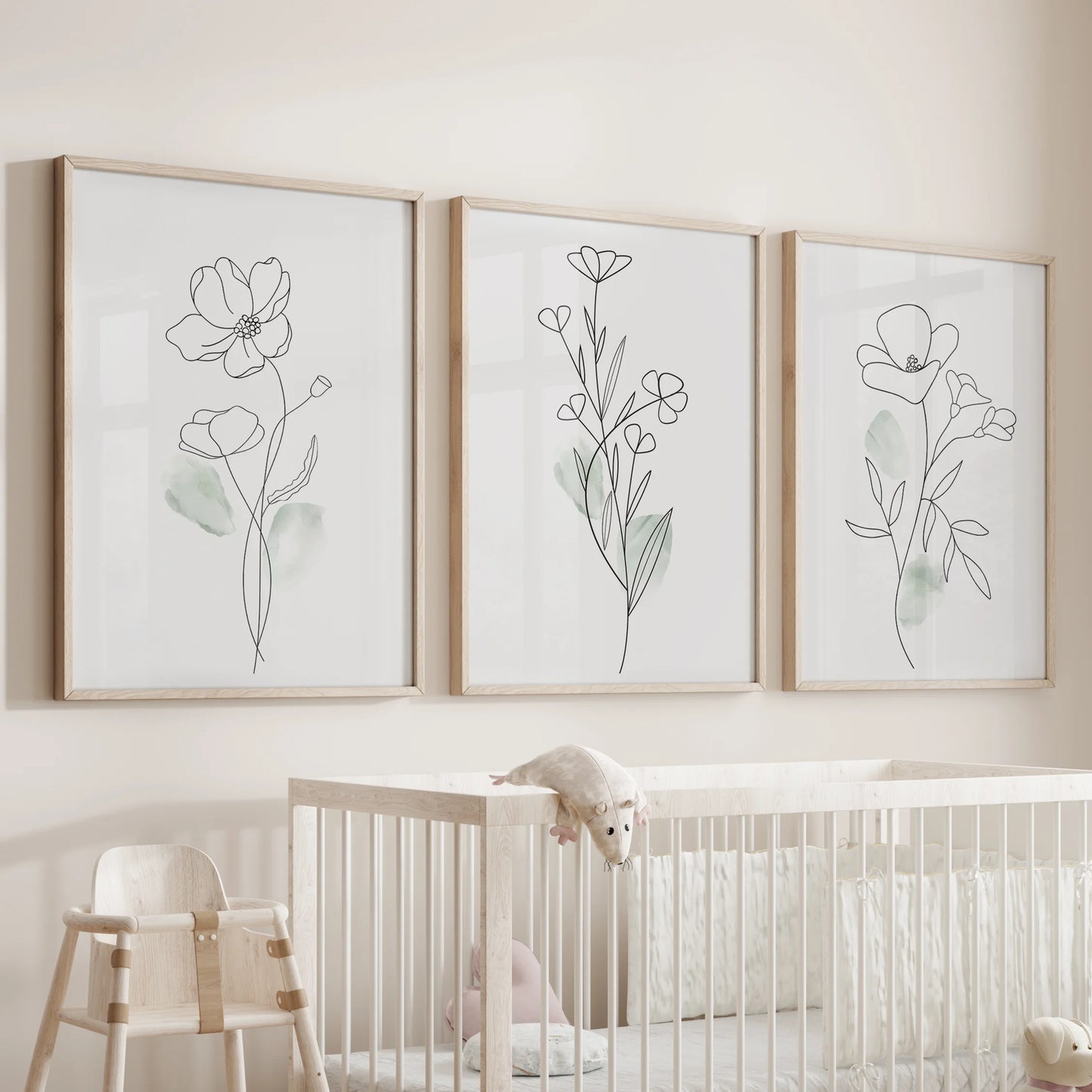 Black line flower illustrations, a wall art set of three in wood frames, watch over the nursery bassinet with gentle botanical outlines and calming simplicity.