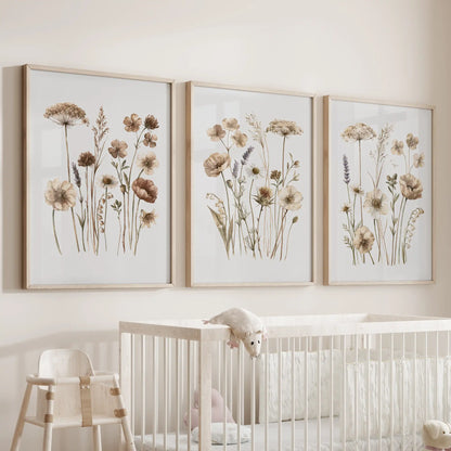Neutral wildflower wall art in three oak frames above a nursery crib.