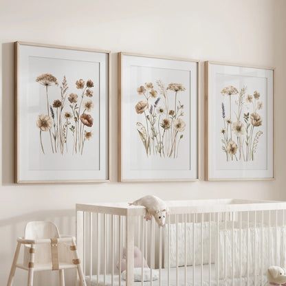 Beige meadow flower prints in oak frames with white mats, a set of three above a crib.