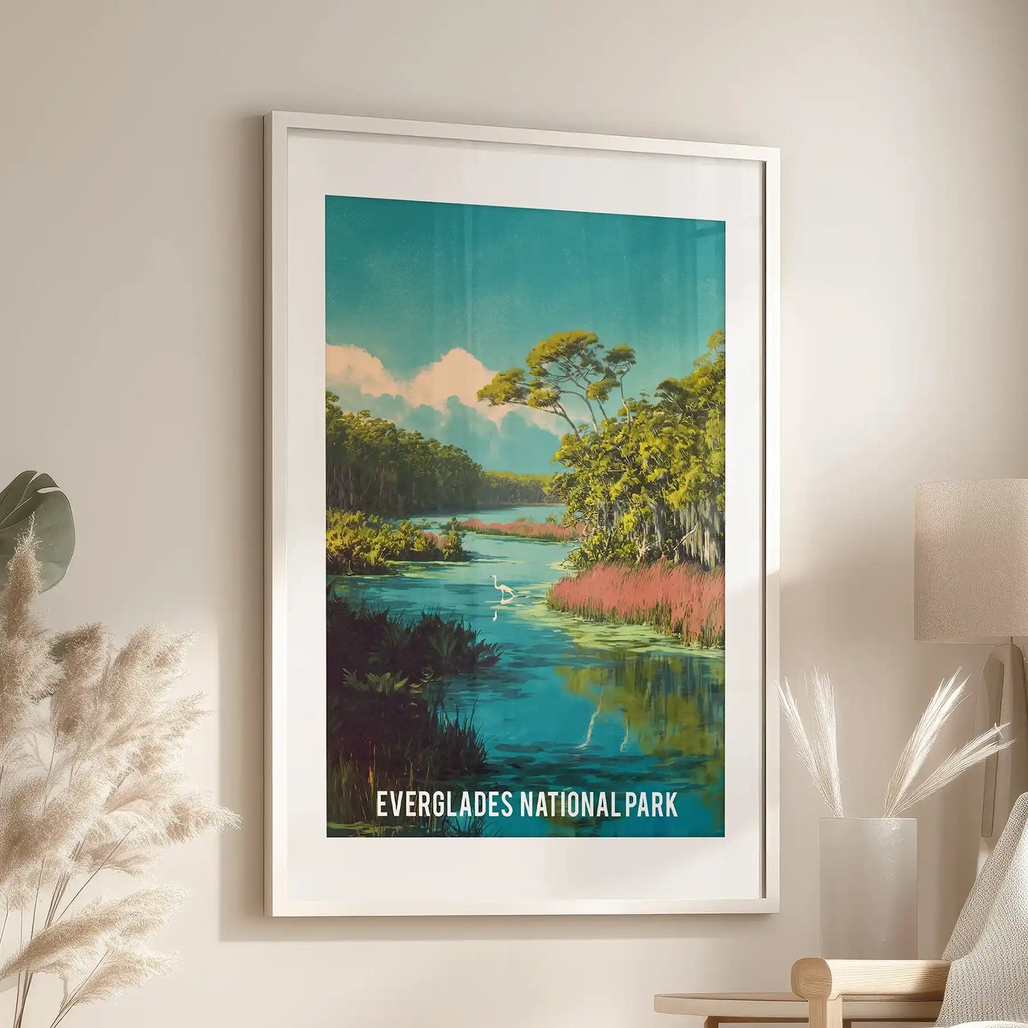 Tropical wilderness panorama home decor print with a white mat frame rests above a reading chair in the lounge, balancing lush greens with tranquil blue water.