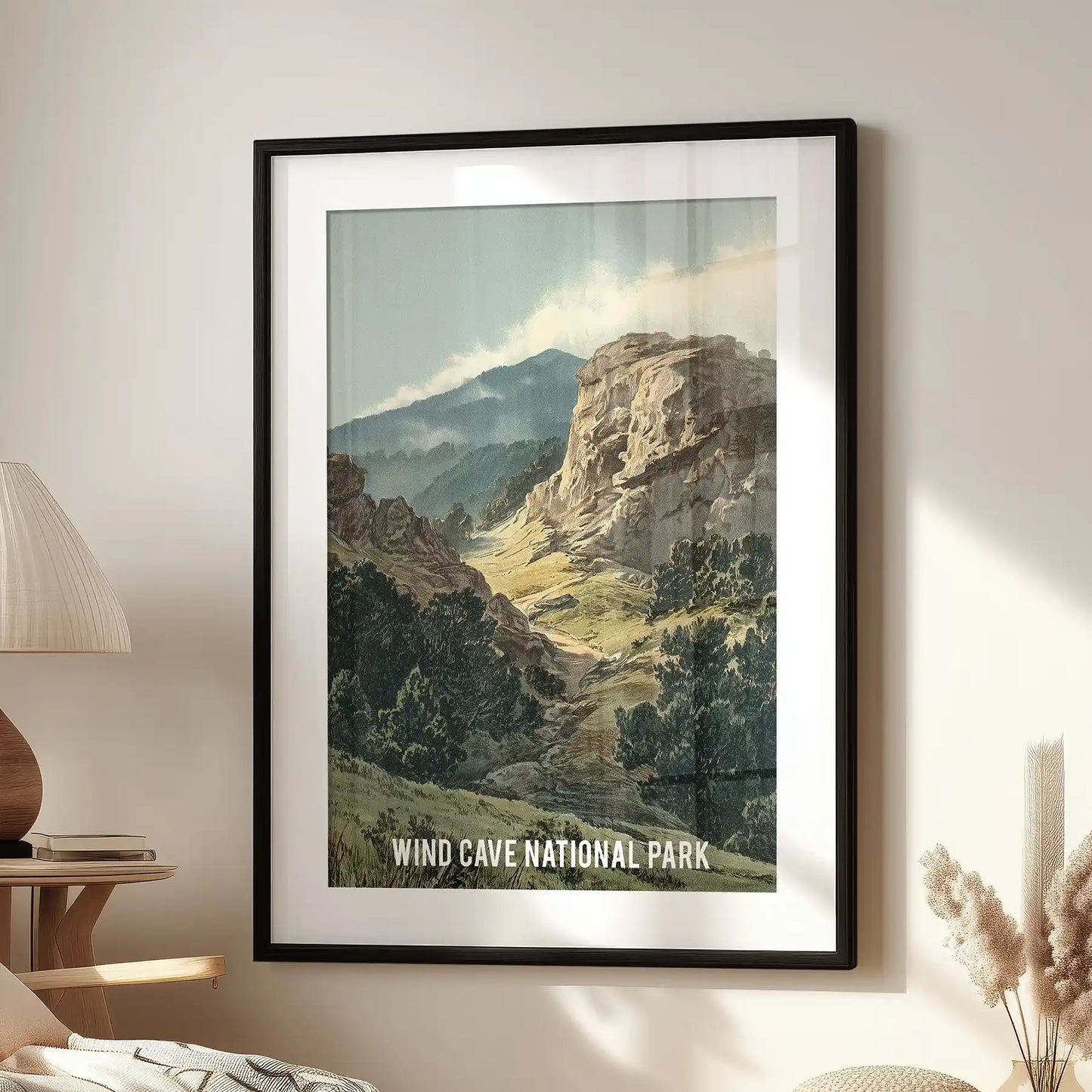 Rocky forest and cliffs statement wall decor in a black frame with mat anchors the family room wall above the lounge seat, evoking a vintage park vibe.