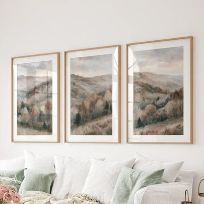 Autumn forest landscape prints, a 3-poster bundle, span the wall over the sectional sofa in the sitting room, matted in natural wood frames.