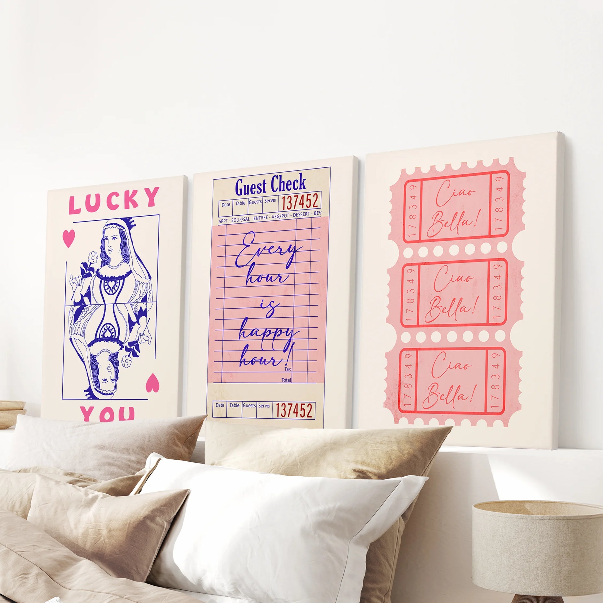 Canvas prints of guest check, ticket stub, and playing card motifs hang as a three-piece gallery above the bed, creating a bold pink focus.