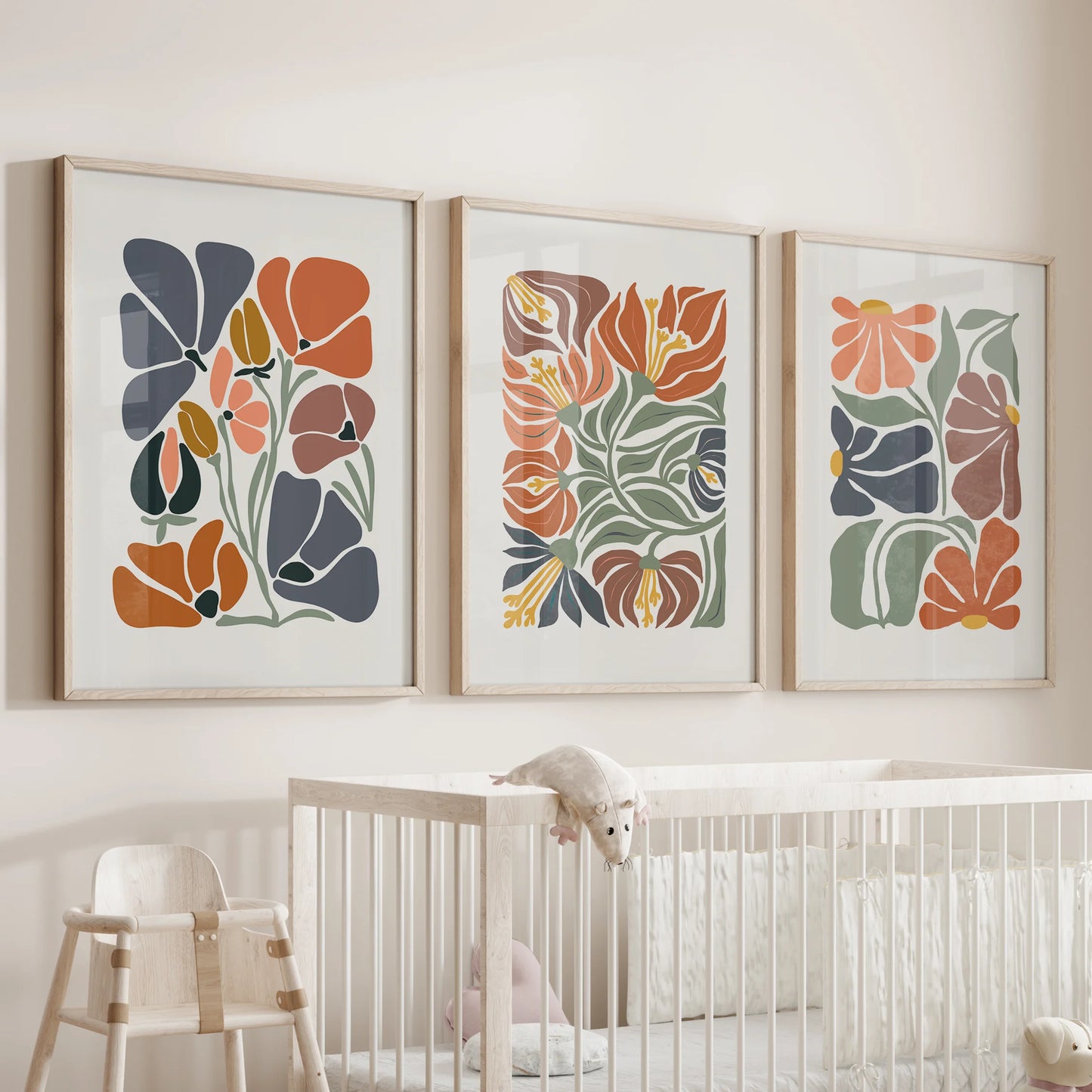 Minimalist plant wall art, a 3-piece print set in thin wood frames, brings calm greenery and terracotta warmth to the nursery above the bassinet.