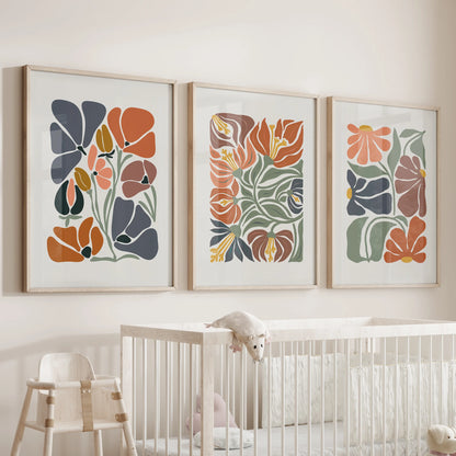 Minimalist plant wall art, a 3-piece print set in thin wood frames, brings calm greenery and terracotta warmth to the nursery above the bassinet.