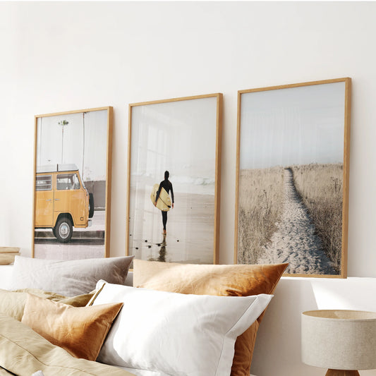 Set of three yellow beach van pictures in oak frames hangs above the bed, filling the bedroom with sun-washed coastal nostalgia.