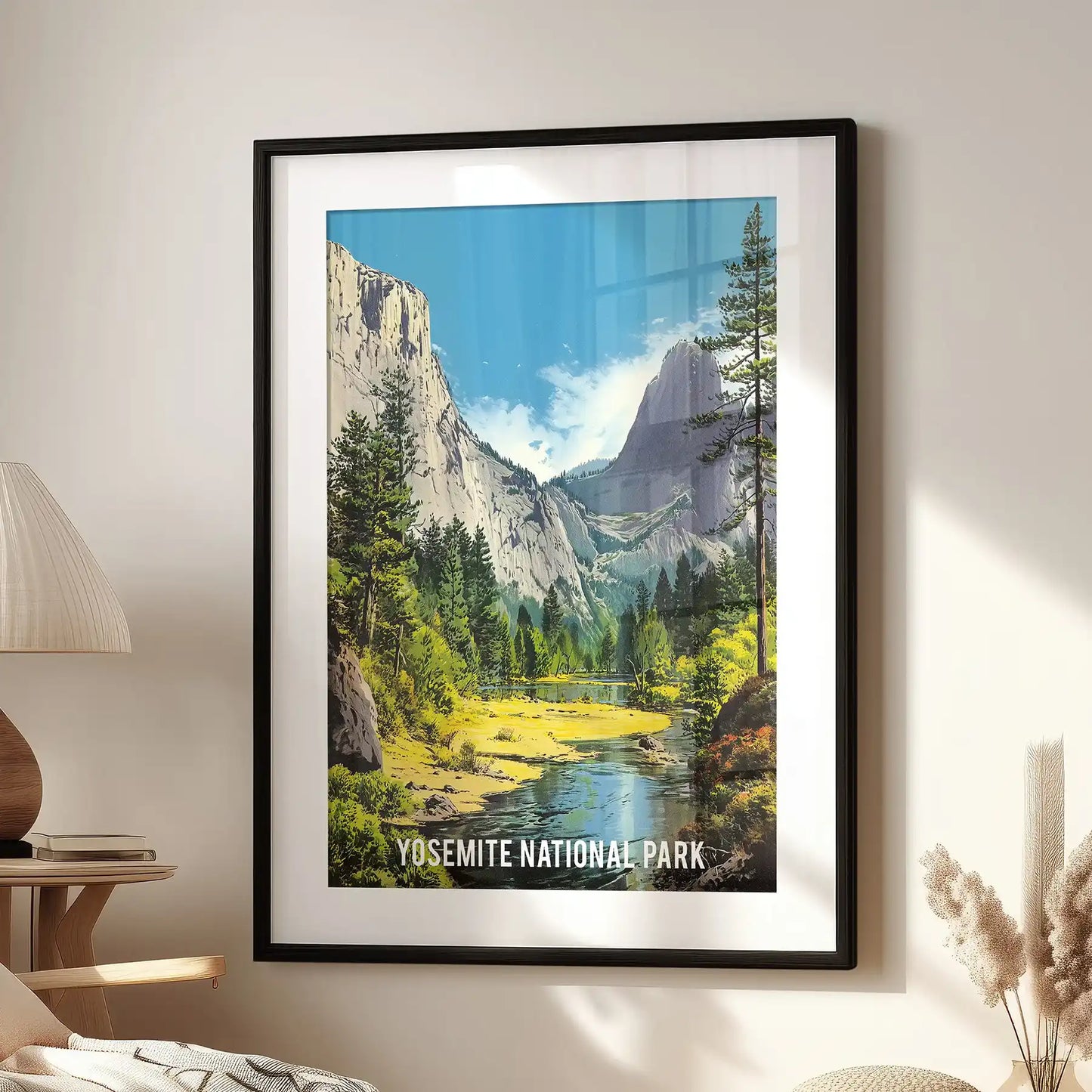 Framed in black mat, this mountain river valley wall piece rests beside a reading chair, bringing a quiet scenic note to the room.