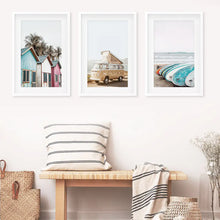 Load image into Gallery viewer, Coastal Set of 3 Prints in Beige, Blue and Pink Tones. Ocean Beach with Surfboards, Cabins, Yellow Travel Van. White Frames with Mat
