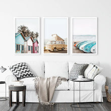 Load image into Gallery viewer, Coastal Set of 3 Prints in Beige, Blue and Pink Tones. Ocean Beach with Surfboards, Cabins, Yellow Travel Van. White Frames
